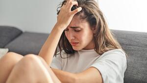 Junge Frau sitzt auf dem Sofa, sie scheint verzweifelt