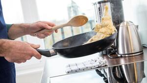 Mann brät Fleisch in einer Pfanne