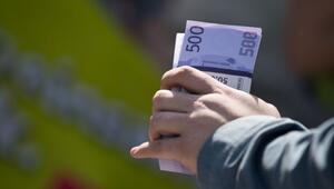 Ein Mann hält ein Bündel mit Spielgeld in der Hand