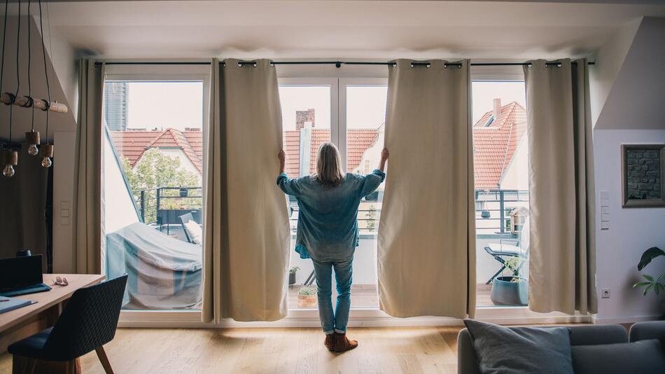 Eine Frau schleisst Gardinen