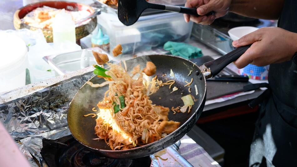 Ein Koch auf dem Thai-Streetfood-Markt