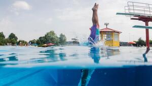 Schwimmer springt vom Sprungturm ins Wasser