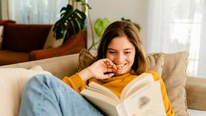Frau mit Buch auf Sofa