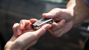 Eine Frau übergibt einen Autoschlüssel