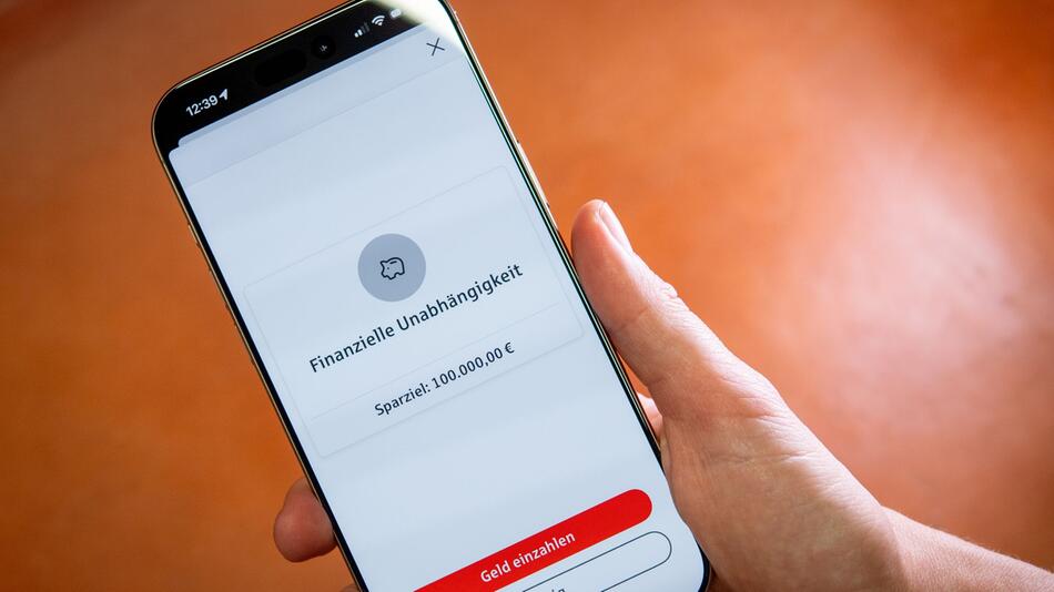 Eine Frau nutzt eine Handy-App zum Sparen