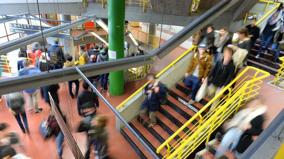 Studierende laufen durch das Treppenhaus einer Hochschule