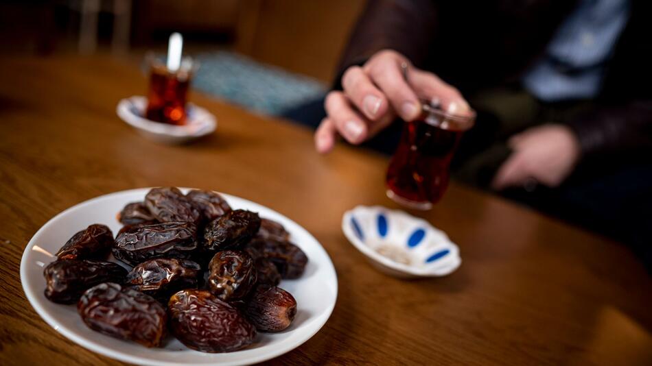 Person sitzt bei Datteln und Tee im Cafe der Sehitlik-Moschee