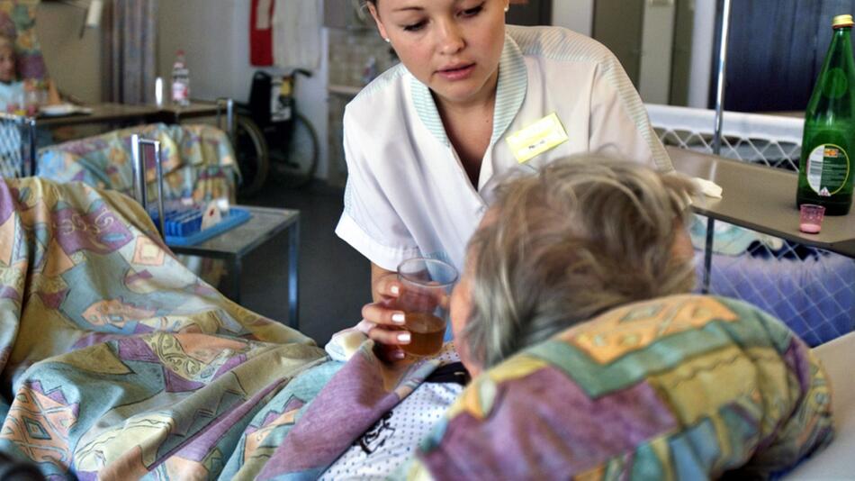Symbolbild: Alte Dame mit Pflegerin im Krankenhaus
