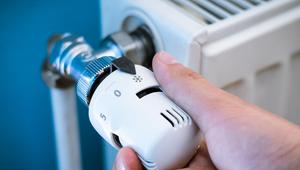 Hand dreht am Heizungsthermostat