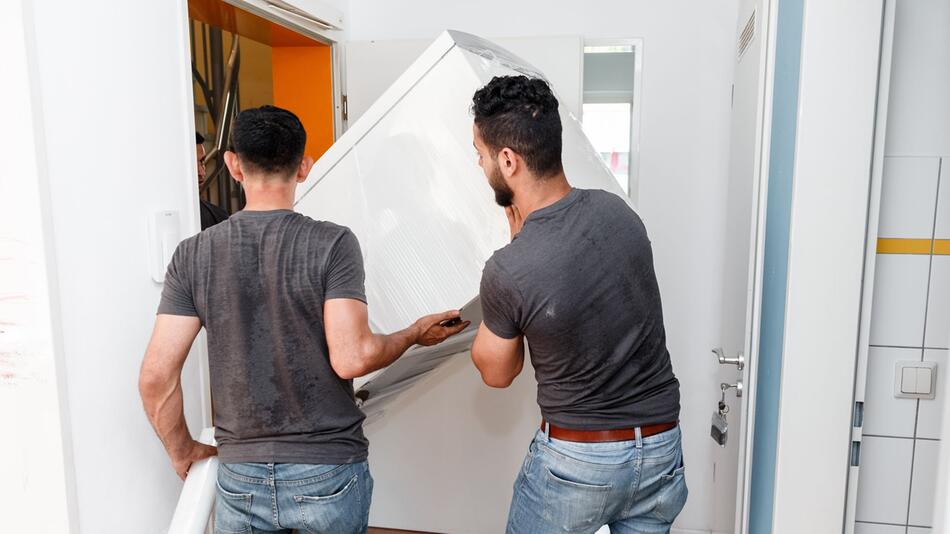 Umzugshelfer transportieren einen Kühlschrank