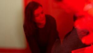 Eine Frau sitzt hinter einer rot bemalten Scheibe