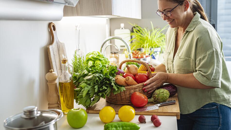 Frau kocht mit Gemüse