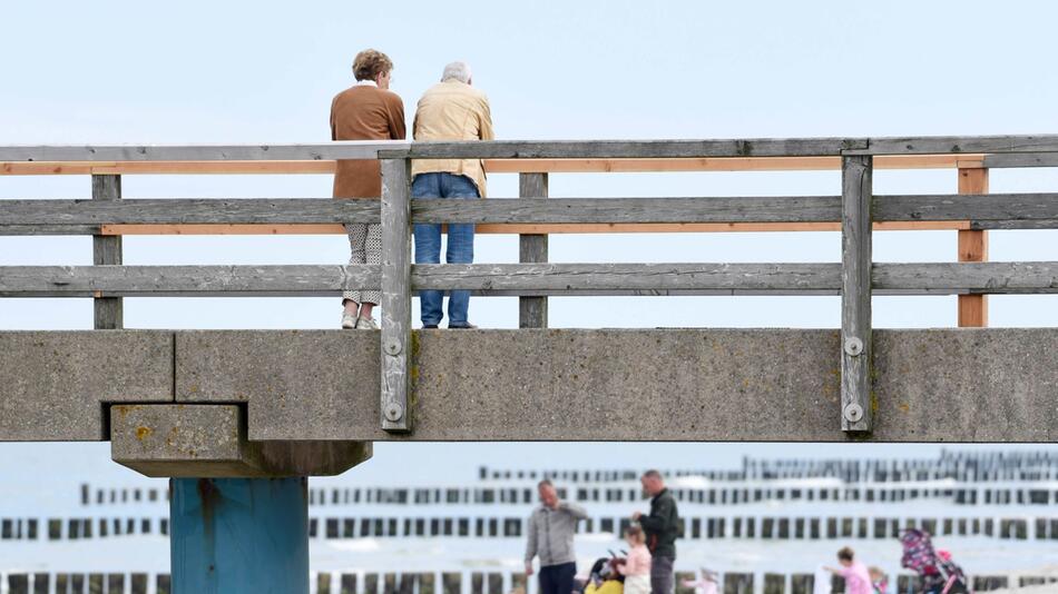 Spaziergänger stehen auf der Seebrücke Graal-Müritz