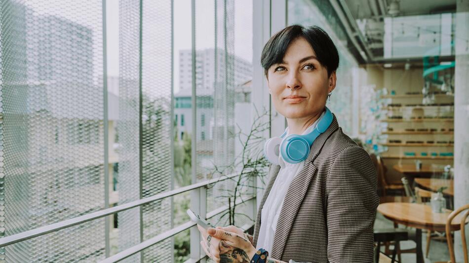 Eine Frau mit Tattoos steht in einem Büro