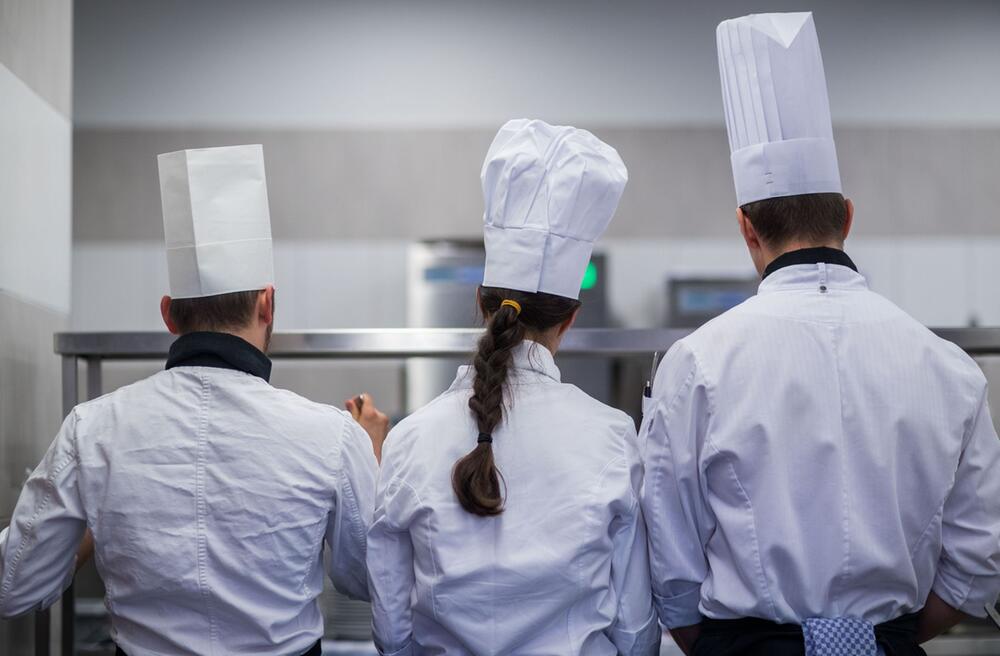 Junge Köche arbeiten an Speisen