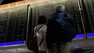 Reisende schauen auf eine Anzeigetafel mit annullierten Flügen