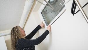 Frau öffnet das Fenster in einem Keller