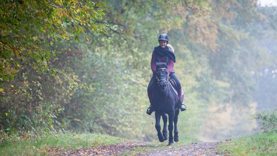 Eine Frau reitet auf einem Pony