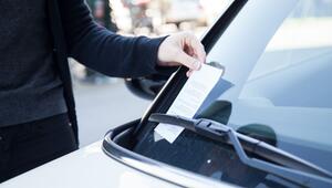 Frau greift nach einem Strafzettel an ihrem Auto