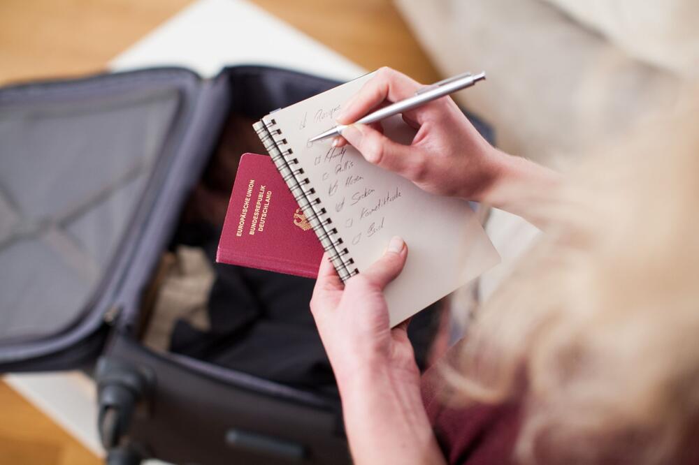 Eine Frau mit Koffer und To-do-Liste