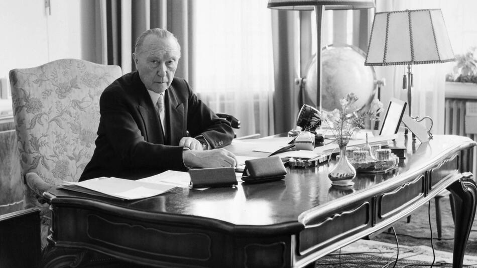 Schwarz-Weiss-Aufnahme von Konrad Adenauer an seinem Schreibtisch im Kanzleramt in Bonn