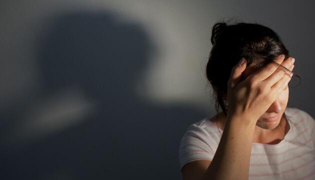 Frau fasst sich an die Stirn