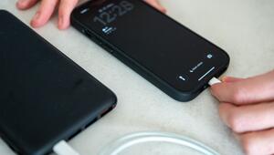 Eine Frau schliesst ein iPhone an eine Powerbank an