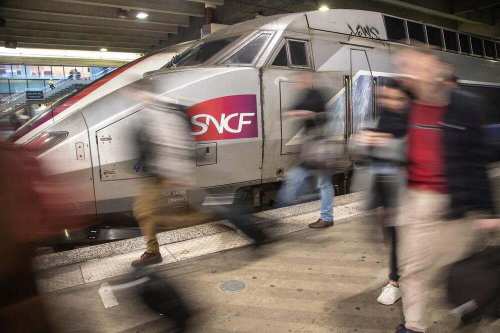 Reisende vor einem Zug des SNCF am Bahnhof Montparnasse