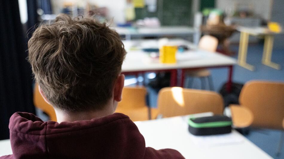 Ein Schüler sitzt an einem Tisch im Klassenzimmer einer Schule