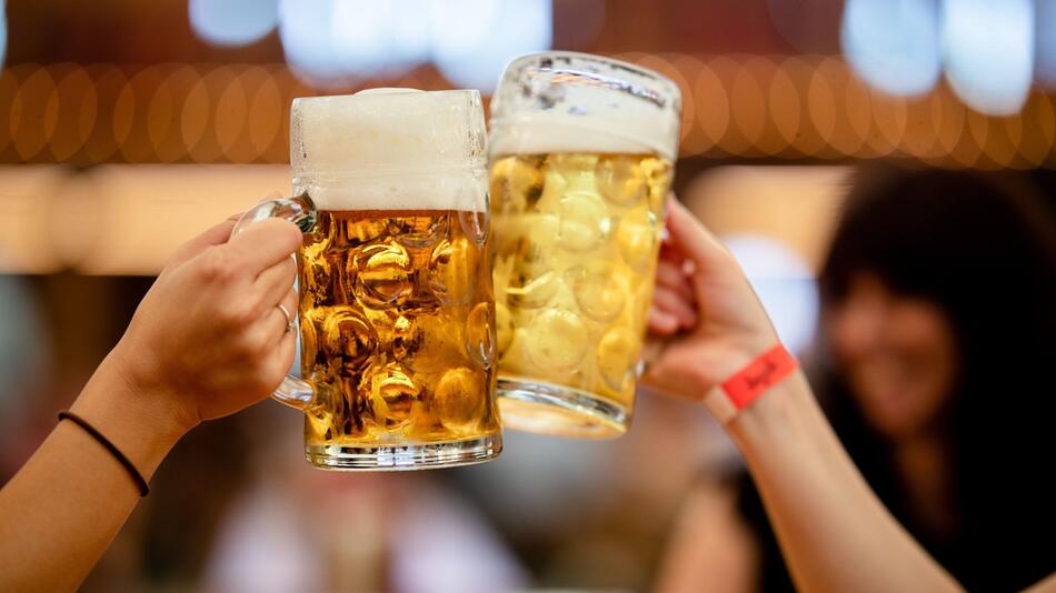 Besucher des Stuttgarter Frühlingsfests stossen mit 2 Mass Bier an