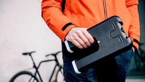 Mann hält den Akku eines E-Bikes in der Hand