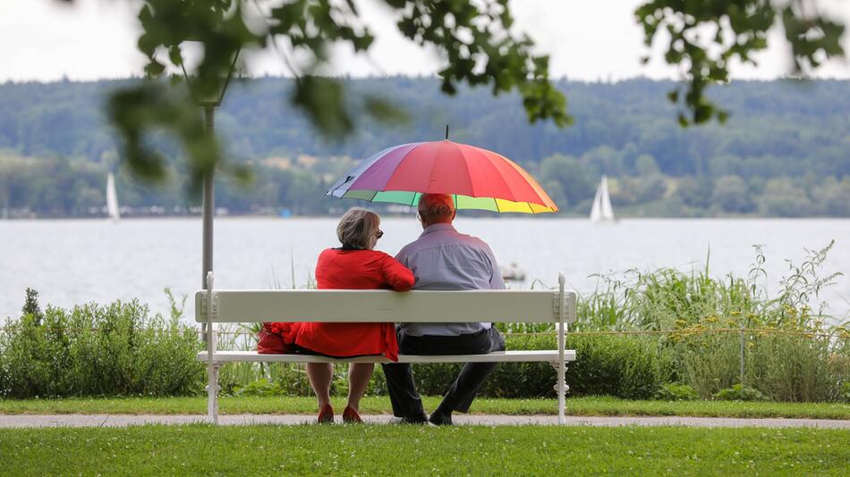 Renter sitzen mit einem Schirm am See