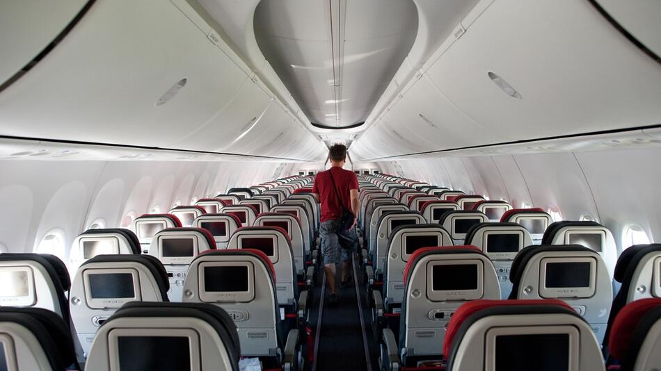 Mann geht durch den Gamg in einem Flugzeug