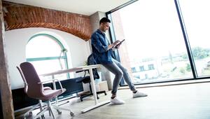 Mann schaut in einem Büro auf ein Tablet