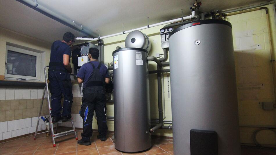 Handwerker installieren eine Wärmepumpe in einem Haus