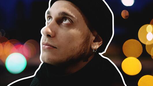 Junger Mann mit Mütze, der nach oben schaut. 