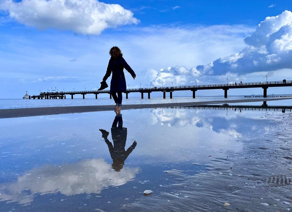 Eine Frau geht am Ostseestrand spazieren