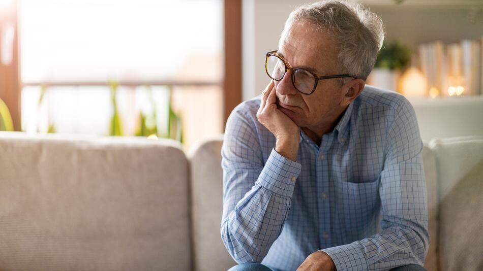 Besorgter Senior sitzt allein in seinem Haus