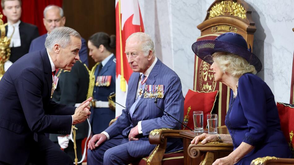 König Charles III. (m.) mit Königin Camilla und Kanadas Premierminister Mark Carney.