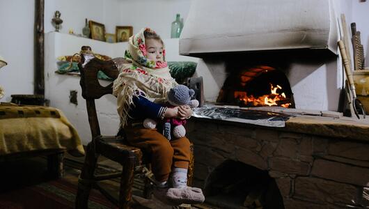 Mädchen sitzt an einem Kamin