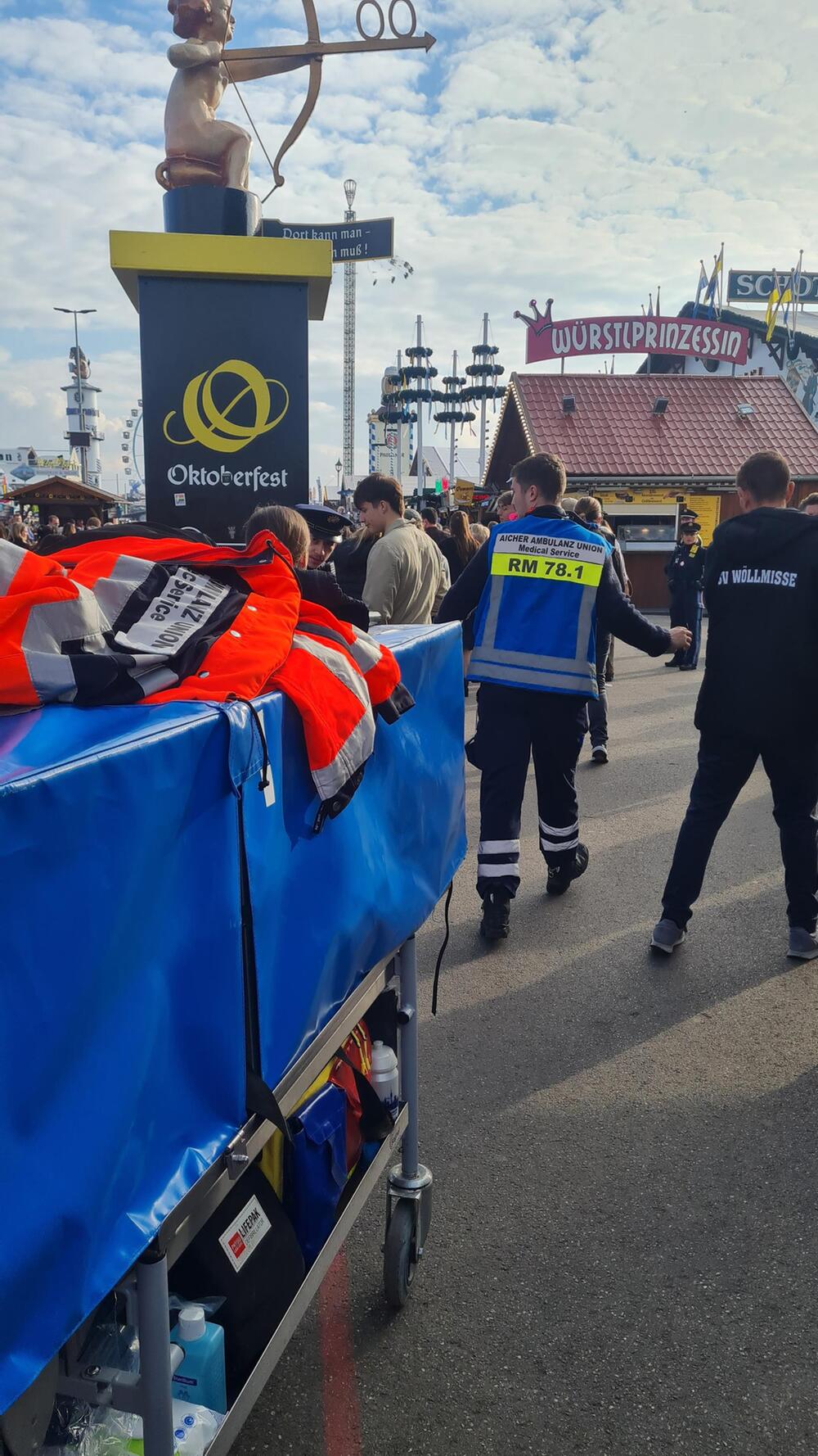 Sanitäter schiebt Leute zur Seite