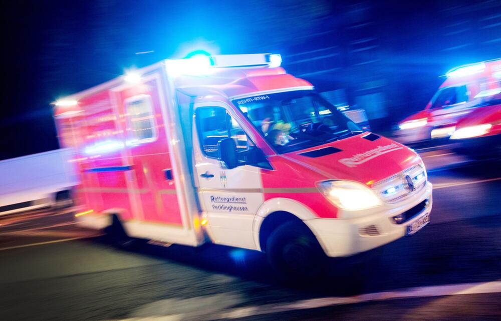 Rettungswagen der Feuerwehr fährt mit Blaulicht durch eine Strasse