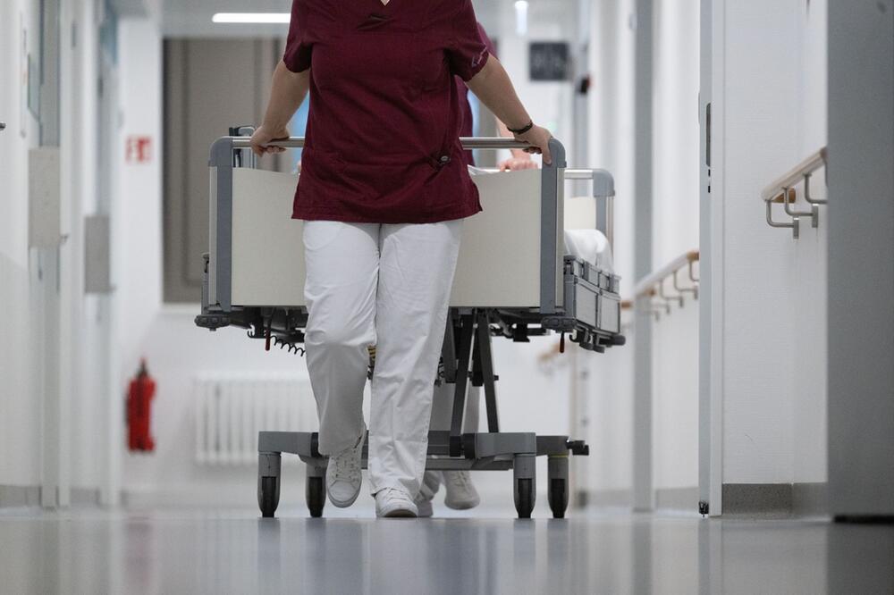 Zwei Krankenpfleger schieben ein Krankenbett
