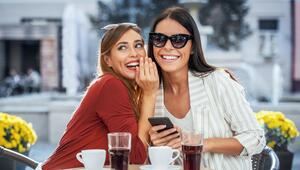 Junge Frauen lachen im Café und Flüstern