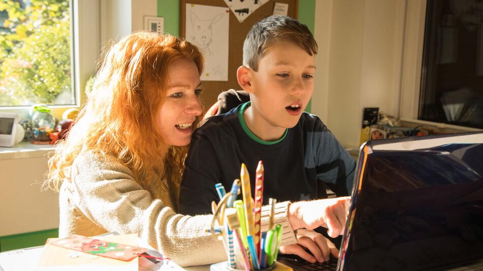 Mutter und Sohn sitzen gemeinsam vor einem Laptop