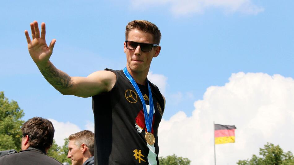 Weltmeister Erik Durm grüsst vor dem Brandenburger Tor ins Publikum