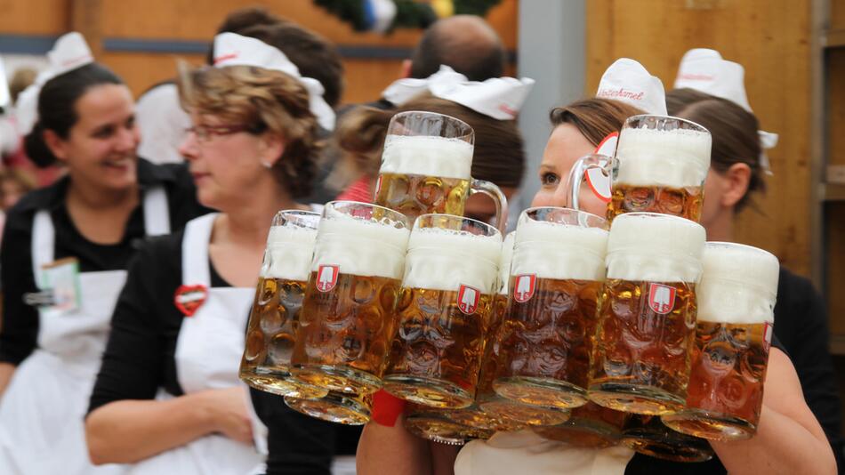 Wiesnbedienung mit zahlreichen Masskrügen in den Händen.