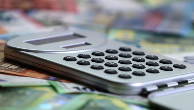 Ein Taschenrechner liegt auf verschiedenen Euro-Banknoten.