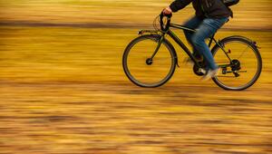 Ein Fahrradfahrer fährt auf einer Strasse mit Herbstblättern