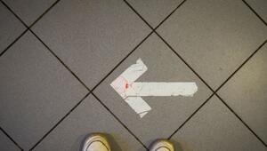 Ein Pfeil aus Klebeband ist auf einem Fussboden zu sehen